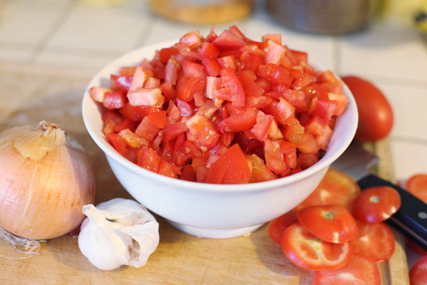 Tomatoes diced, onion and garlic next to come.