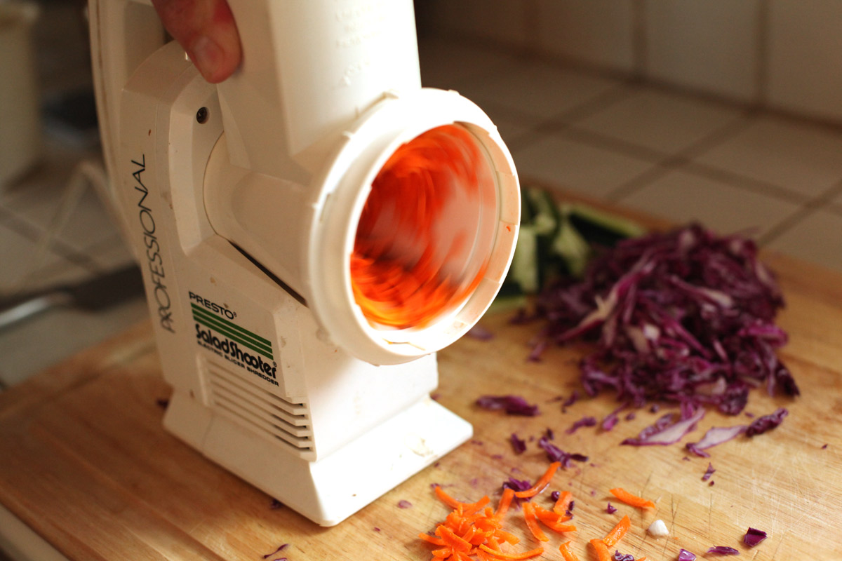 Using the salad shooter to grate carrots.